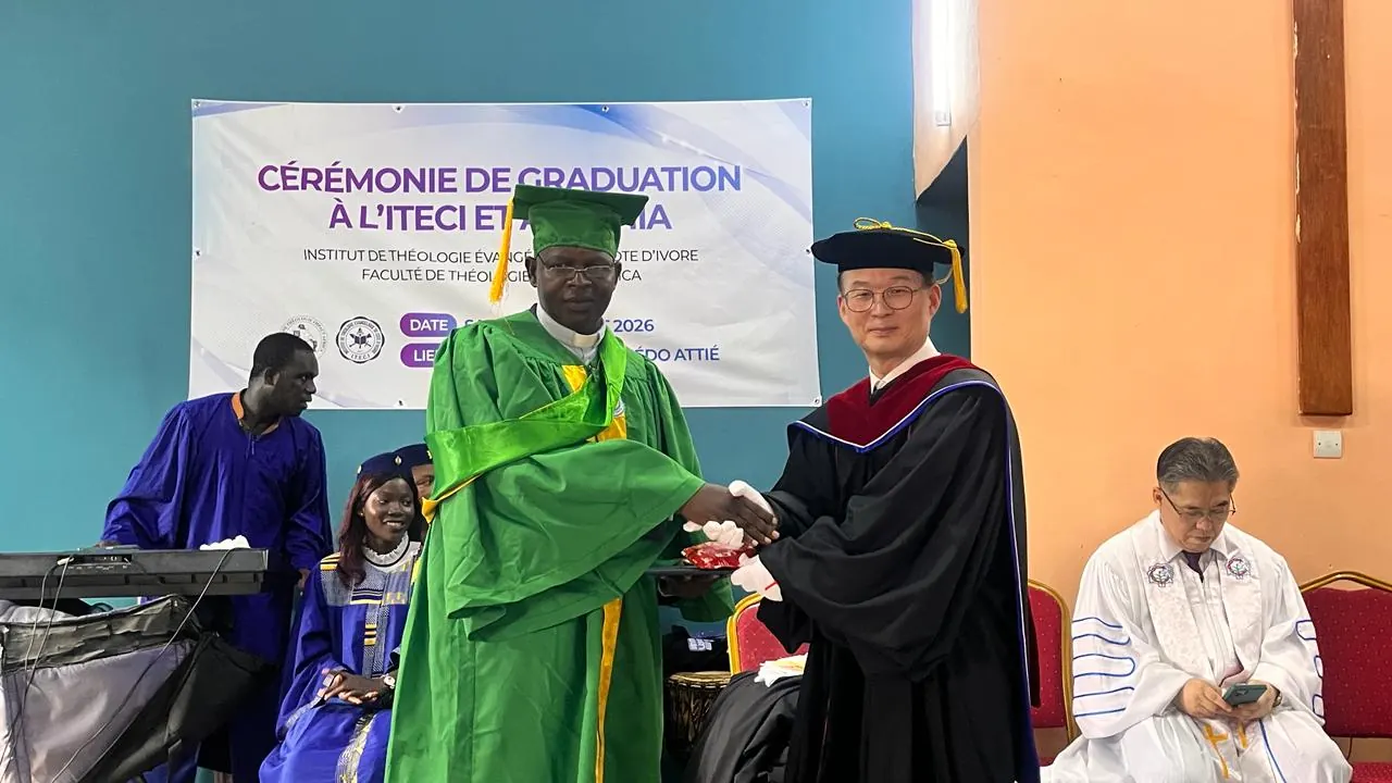 Étudiante en toge verte recevant une distinction